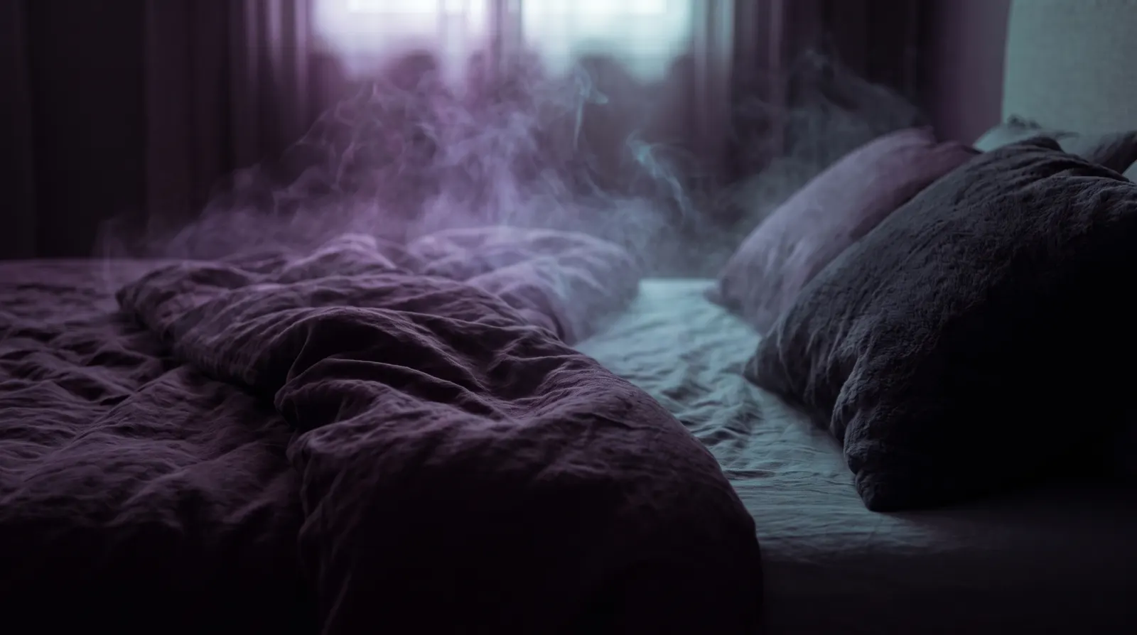 Pillow on a dark bed at dawn with faint lavender and aqua mist dissolving into the air above it.